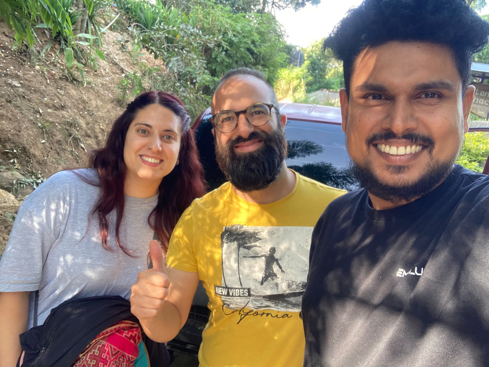 A guide taking a selfie with two smiling guests who give a thumbs up during a Sri Lanka tour
